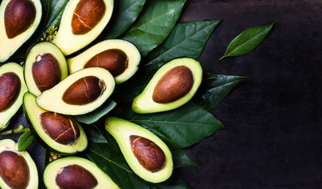 Leaves and avocado halves fanned out from left to right.