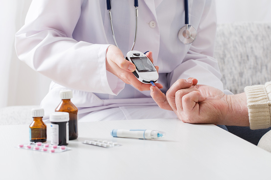 : Doctor using glucose monitor to check patient’s diabetes level.