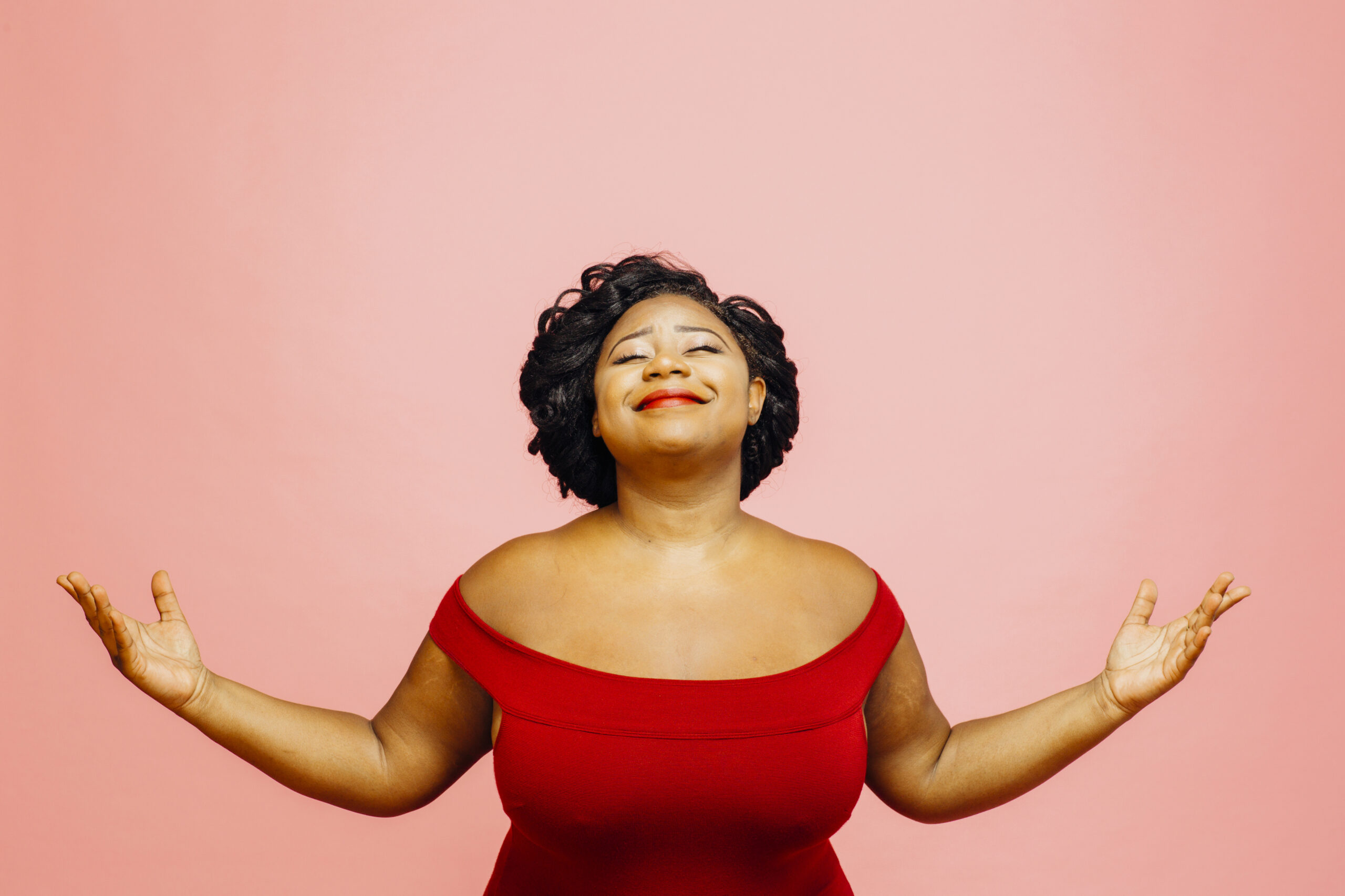 Plus size woman wearing red dress and feeling confident after undergoing bariatric surgery.