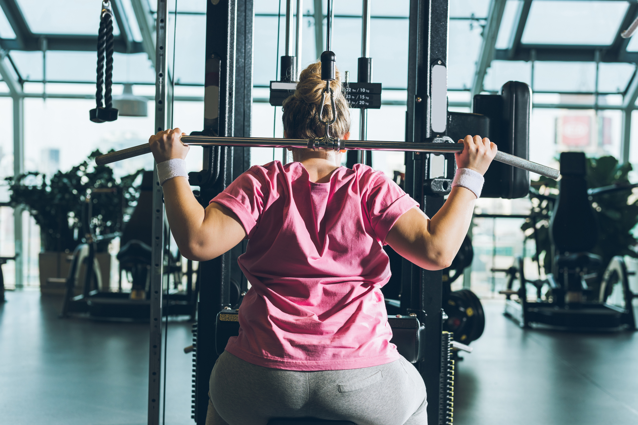 Woman with obesity working out on training apparatus